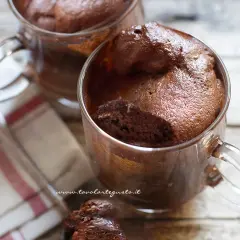 Due golose tortine in tazza al microonde, soffici e al cioccolato, pronte per essere gustate.