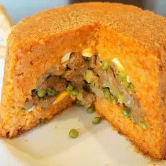 Un gustoso sartu di riso, con ripieno di carne, piselli e uova, cotto fino a doratura.