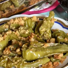 Friggitelli al forno, verdi e succosi, cosparsi di pangrattato croccante. Un contorno saporito e invitante.