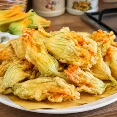Fiori di zucca fritti, croccanti e dorati, preparati con una leggera pastella per fiori di zucca.