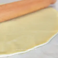 Mattarello stende la pasta brise su carta forno, pronta per una torta salata.