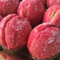 Dolci pesche ricoperte di zucchero scintillante, pronte per essere gustate.