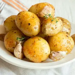 Patate lesse al microonde condite con erbe e aglio, pronte per essere gustate.