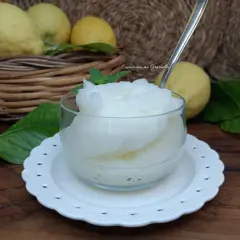 Una coppa di granita al limone, fresca e dissetante, con limoni freschi sullo sfondo.