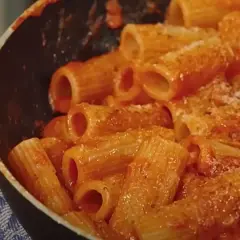 Rigatoni conditi con un sugo rosso ricco e cremoso, pronti per essere gustati in una **pasta alla zozzona** da leccarsi i baffi.