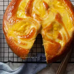 Torta soffice con un vortice di crema pasticcera dorata, appena sfornata e pronta per essere gustata.