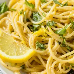 Spaghetti al limone freschi e profumati, guarniti con scorza di limone e basilico. Un piatto leggero e saporito.