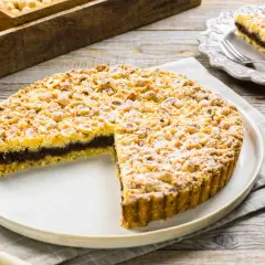 Sbriciolata alla Nutella con tante nocciole croccanti, una fetta tagliata mostra il ripieno goloso.