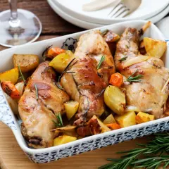 Delizioso coniglio al forno con patate e carote, profumato al rosmarino. Un piatto rustico e saporito, pronto per essere gustato.