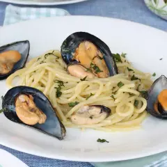 Spaghetti con le cozze in bianco, un piatto semplice e gustoso, con cozze fresche e prezzemolo tritato.