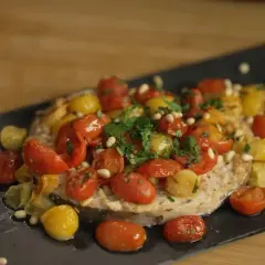 Pesce spada in friggitrice ad aria, condito con pomodorini colorati, pinoli e prezzemolo fresco. Un piatto leggero e saporito.