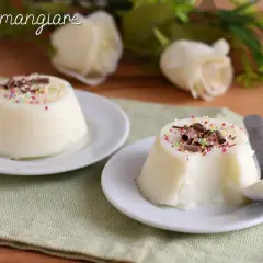 Due biancomangiare decorati con codette colorate e riccioli di cioccolato, pronti per essere gustati.