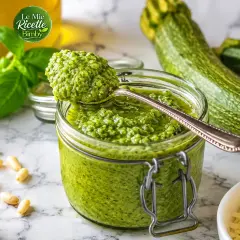 Pesto di zucchine Bimby in un barattolo, con basilico, pinoli, aglio e zucchine fresche.