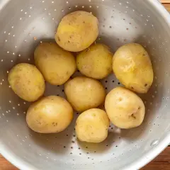 Patate bollite appena scolate in un colino, pronte per essere condite.