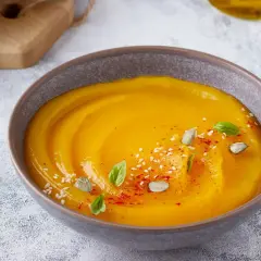 Vellutata di zucca cremosa, guarnita con semi di zucca, sesamo, paprika e basilico. Servita con crostini dorati.