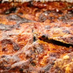 Parmigiana di melanzane non fritte, dorata e invitante, con strati di melanzane, pomodoro e formaggio filante. Una delizia leggera e gustosa.
