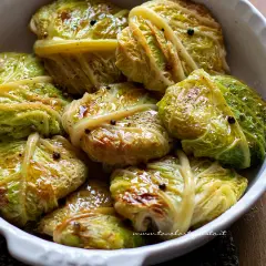 Involtini di verza succulenti, conditi con pepe nero e spezie, in una ciotola bianca.