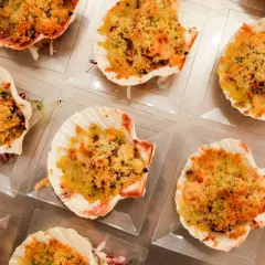 Deliziose capesante gratinate, servite in conchiglie, pronte per essere gustate.