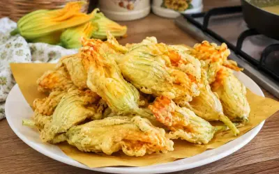 Fiori di zucca fritti, croccanti e dorati, preparati con una leggera pastella per fiori di zucca.