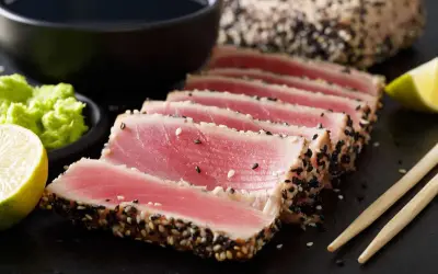Tonno scottato in crosta di sesamo, perfetto per scoprire come cucinare il tonno fresco. Servito con lime, wasabi e salsa di soia.