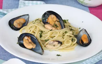 Spaghetti con le cozze in bianco, un piatto semplice e gustoso, con cozze fresche e prezzemolo tritato.