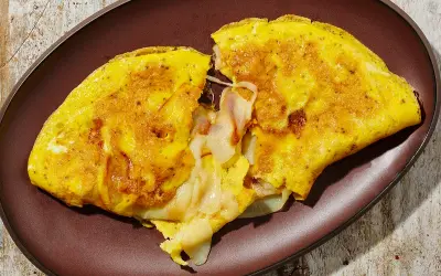 Omelette dorata e soffice, ripiena di formaggio filante. Una deliziosa omelette ricetta per una colazione o un pasto veloce.