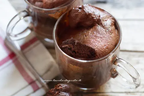 Due golose tortine in tazza al microonde, soffici e al cioccolato, pronte per essere gustate.