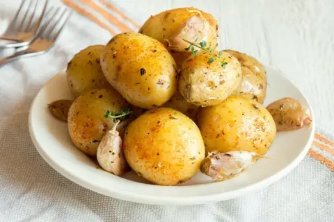 Patate lesse al microonde condite con erbe e aglio, pronte per essere gustate.