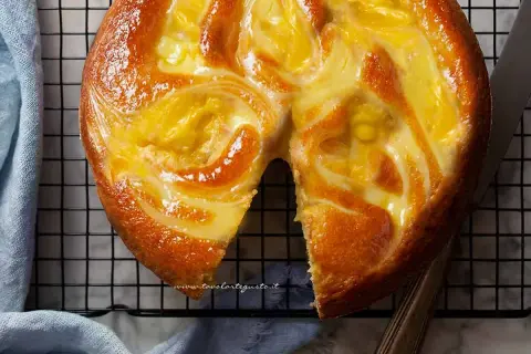Torta soffice con un vortice di crema pasticcera dorata, appena sfornata e pronta per essere gustata.
