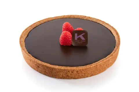 Una deliziosa crostata al cioccolato, con tre lamponi freschi e il logo di Ernst Knam.