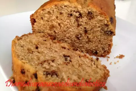 Plumcake con gocce di cioccolato, soffice e invitante, tagliato a fette su un piatto bianco.