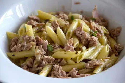 Penne al tonno, un piatto semplice e gustoso, con abbondante tonno sminuzzato e qualche fogliolina di basilico.