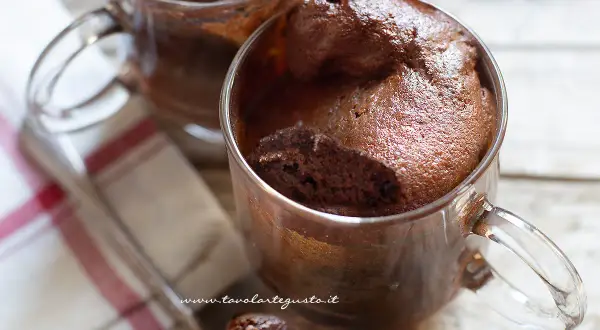 Due golose tortine in tazza al microonde, soffici e al cioccolato, pronte per essere gustate.