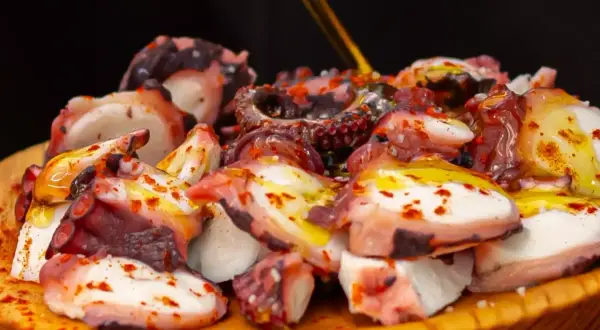 Pezzi di polpo succulento, conditi con olio e paprika, pronti per la cottura. Un piatto che celebra la bontà del mare.