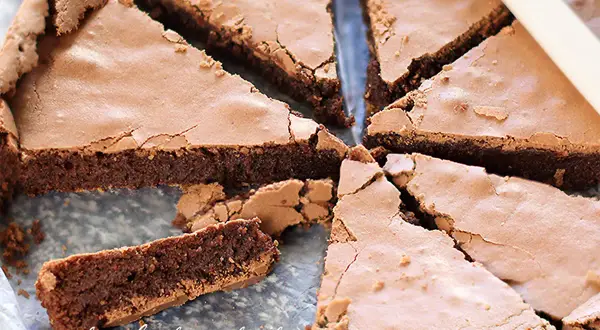 Fetta di torta tenerina al cioccolato, con crosta croccante e interno morbido, pronta per essere gustata.