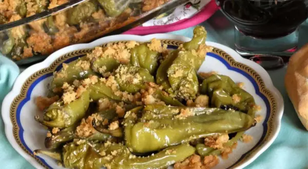 Friggitelli al forno, verdi e succosi, cosparsi di pangrattato croccante. Un contorno saporito e invitante.