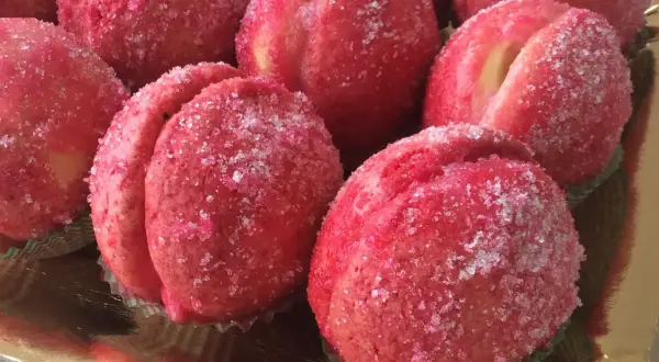 Dolci pesche ricoperte di zucchero scintillante, pronte per essere gustate.