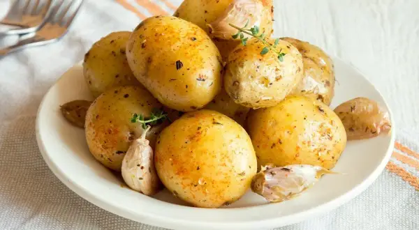 Patate lesse al microonde condite con erbe e aglio, pronte per essere gustate.