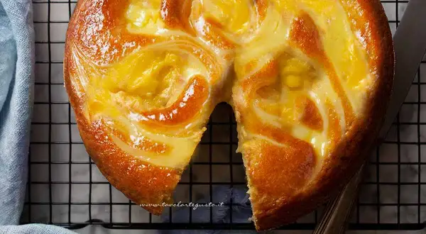 Torta soffice con un vortice di crema pasticcera dorata, appena sfornata e pronta per essere gustata.