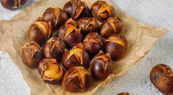 Castagne perfette cotte in friggitrice ad aria, con la buccia leggermente aperta che rivela il frutto dorato.
