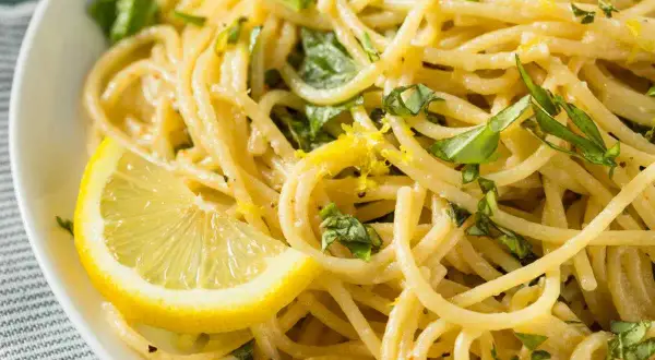 Spaghetti al limone freschi e profumati, guarniti con scorza di limone e basilico. Un piatto leggero e saporito.