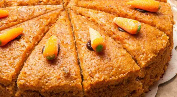 Fetta di torta carote e noci, decorata con caramelle a forma di carota.