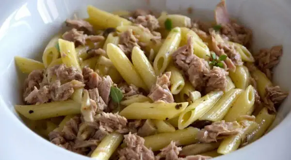 Penne al tonno, un piatto semplice e gustoso, con abbondante tonno sminuzzato e qualche fogliolina di basilico.
