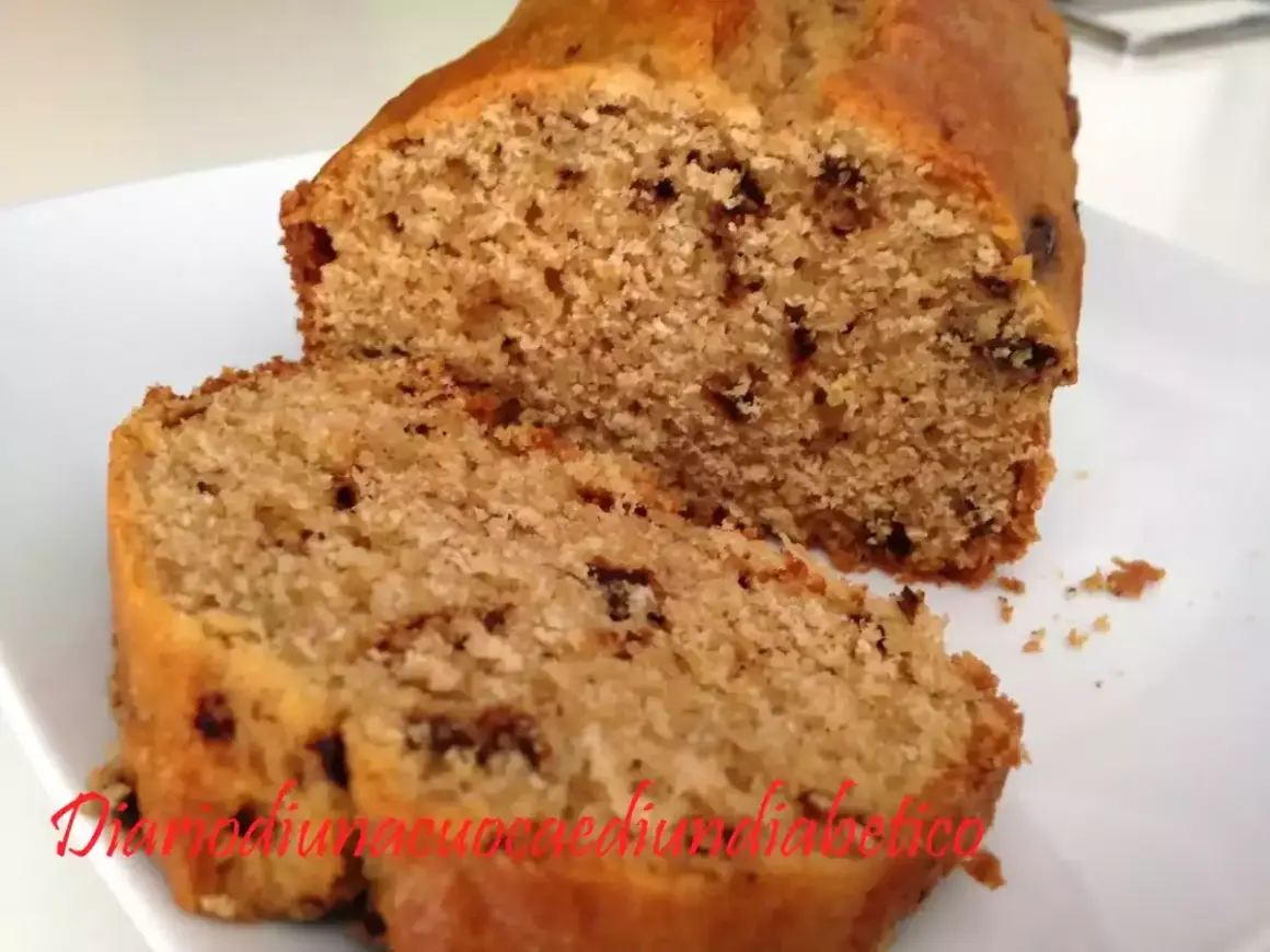 Plumcake con gocce di cioccolato, soffice e invitante, tagliato a fette su un piatto bianco.