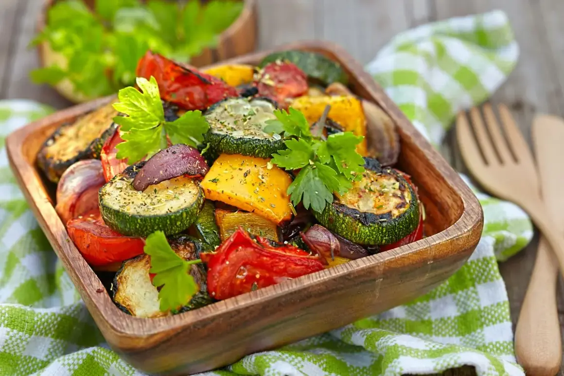 Un misto colorato di verdure in friggitrice ad aria, tra cui zucchine, peperoni e pomodori, guarnito con prezzemolo fresco.