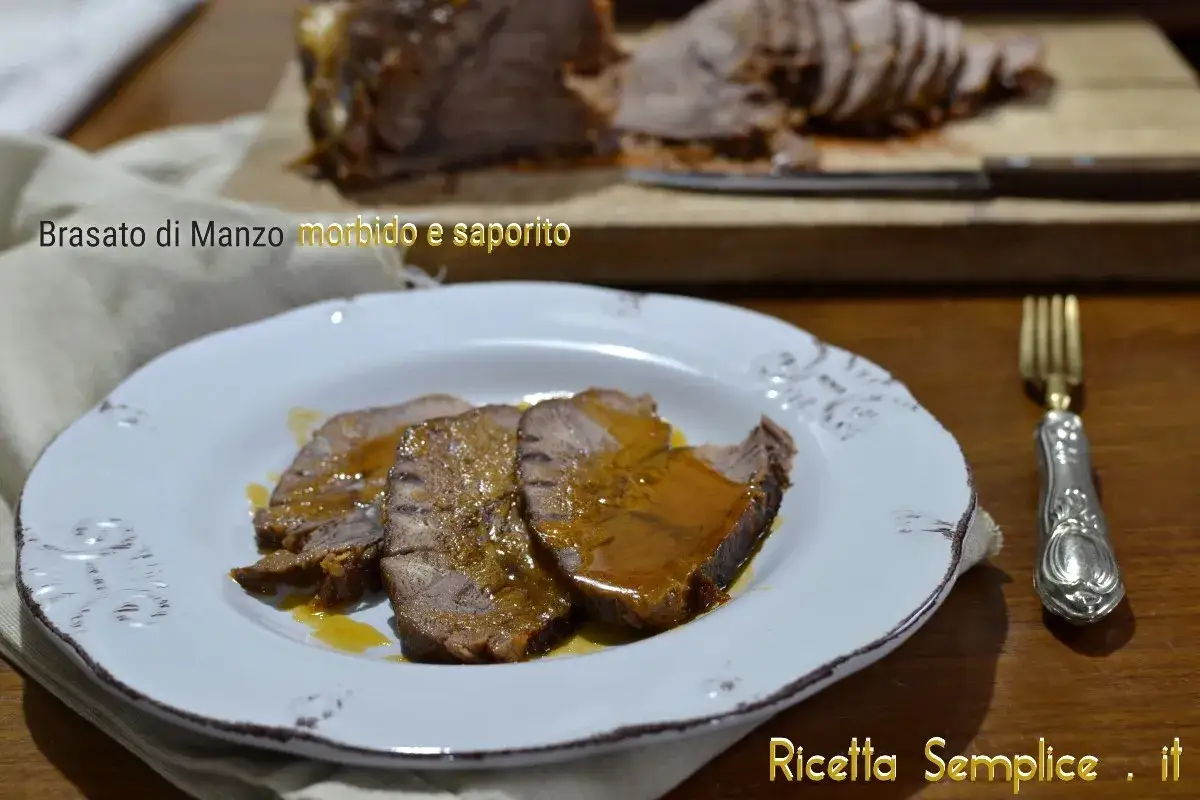 Fette di brasato di manzo succulento su un piatto bianco, con il resto della carne affettata sullo sfondo.