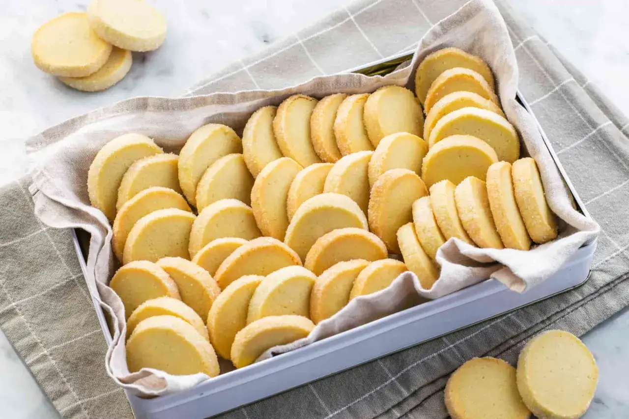 Scatola piena di deliziosi biscotti al burro, dorati e friabili, pronti per essere gustati.