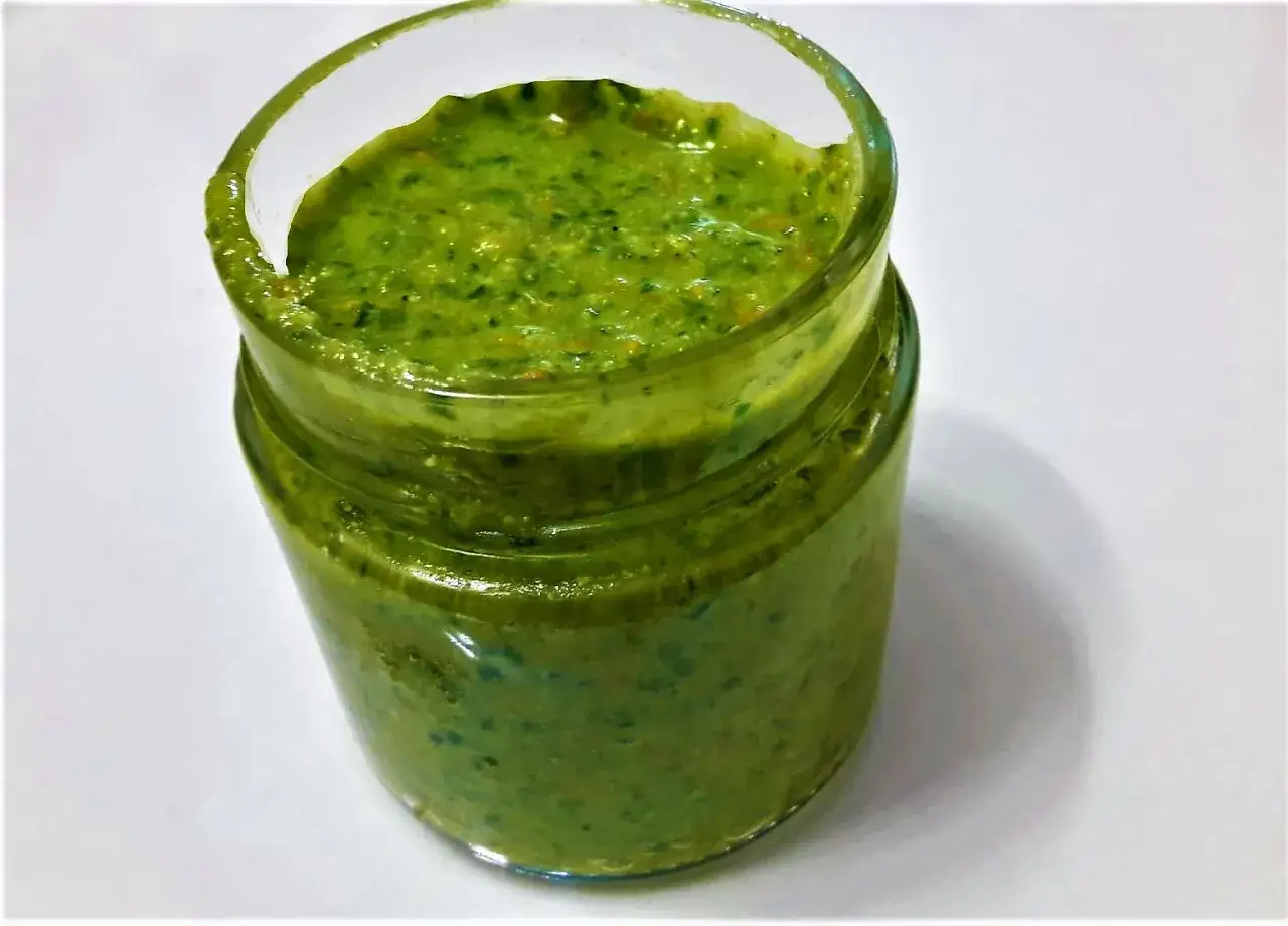 Vasetto di pesto fatto in casa con il Bimby, dal colore verde brillante e consistenza rustica.