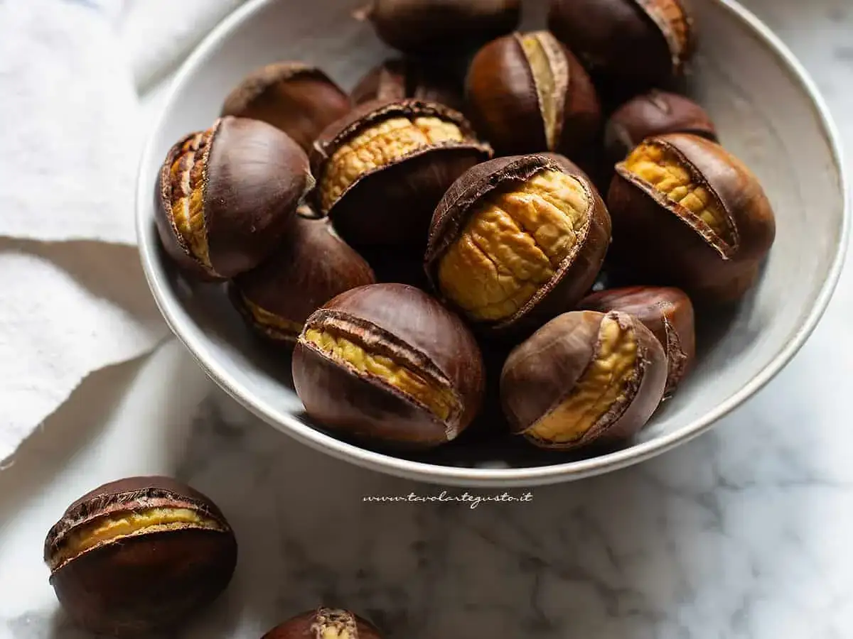 Castagne in friggitrice ad aria, pronte per essere gustate. Il loro guscio scuro si apre rivelando un interno dorato e invitante.