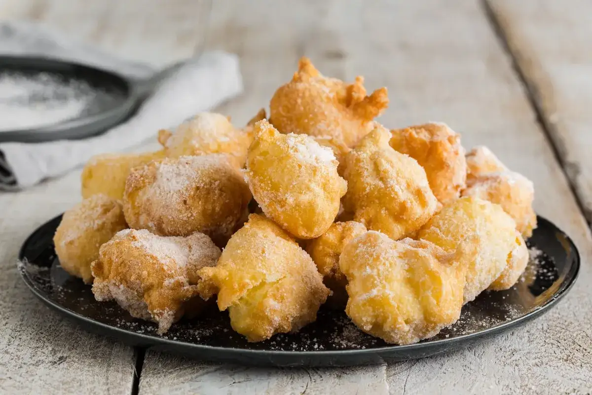 Frittelle di una volta, dorate e soffici, cosparse di zucchero a velo. Un dolce che sa di casa e tradizione.